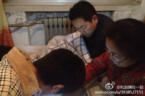 赵赟和他的家人在看爱心人士给他们的留言