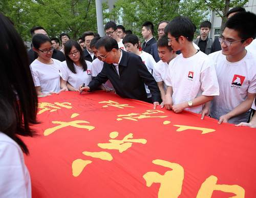 在山鹰社社旗上签名  图片来源：中国政府网