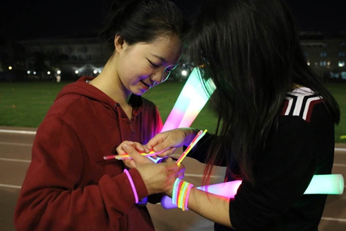 参与者相互帮助戴上“荧光手环”